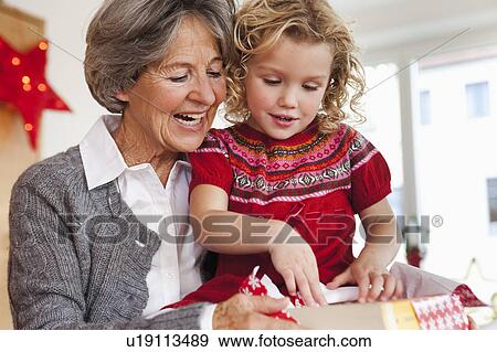 Stock Photo - grandma and grandchild opening present. Fotosearch