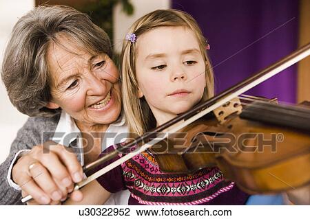 Stock Image - grandma teaching grandchild music. Fotosearch
