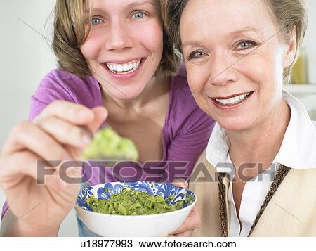 Grandmother and mother feeding baby View Large Photo Image Stock Image - Grandmother and mother feeding baby. Fotosearch