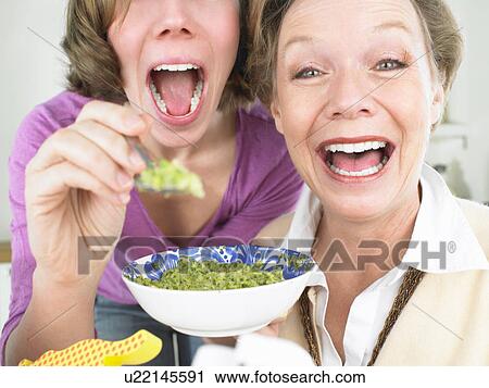 Grandmother and mother feeding baby View Large Photo Image Stock Image - Grandmother and mother feeding baby. Fotosearch