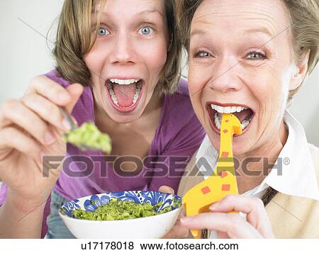 Grandmother and mother feeding baby View Large Photo Image Stock Photo - Grandmother and mother feeding baby. Fotosearch