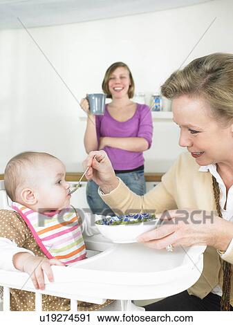 Grandmother feeding baby View Large Photo Image Stock Image - Grandmother feeding baby. Fotosearch
