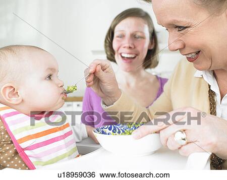 Stock Photograph - Grandmother feeding baby. Fotosearch