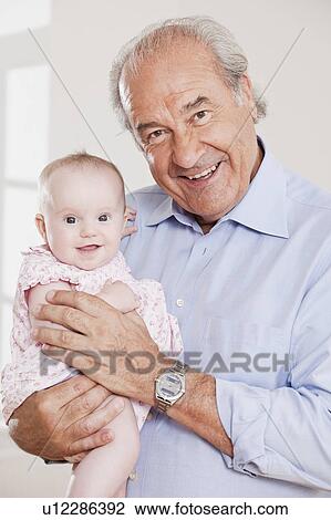 Stock Image - Grandpa holding a baby. Fotosearch