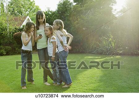 Group of girls looking at mobile phone View Large Photo Image Picture - Group of girls looking at mobile phone. Fotosearch