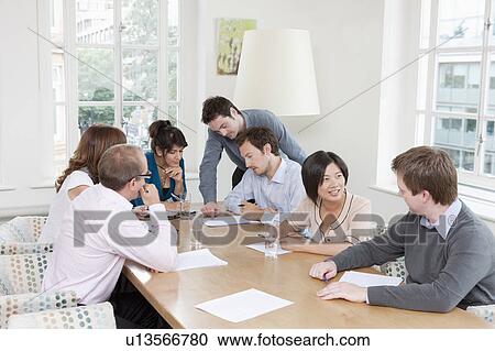 Group of people at a conference table View Large Photo Image Stock Image - Group of people at a conference table. Fotosearch