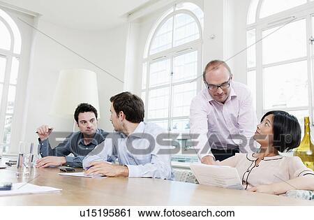 Stock Image - Group of people at a conference table. Fotosearch