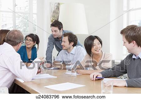 Group of people at a conference table View Large Photo Image Stock Photograph - Group of people at a conference table. Fotosearch
