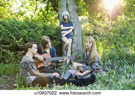 Group of young adults together in garden View Large Photo Image Stock Image - Group of young adults together in garden. Fotosearch