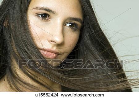 Picture - hair blowing across girls face. Fotosearch