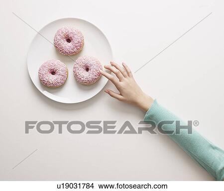 Hand reaching for a doughnut View Large Photo Image Picture - Hand reaching for a doughnut. Fotosearch