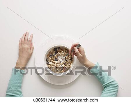 Picture - Hands by a bowl of cereal. Fotosearch