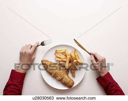 Hands by a plate of fish and chips View Large Photo Image Stock Image - Hands by a plate of fish and chips. Fotosearch