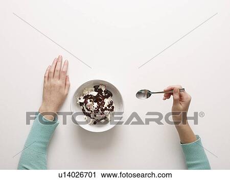 Stock Image - Hands by bowl of desert. Fotosearch