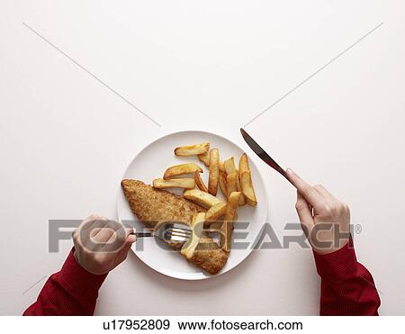 Stock Photo - Hands by plate of fish and chips. Fotosearch