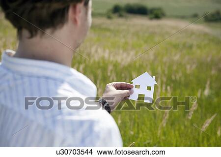 Hands holding cut-out paper houses View Large Photo Image Picture - Hands holding cut-out paper houses. Fotosearch