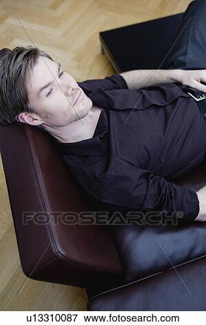 handsome man relaxing in a chair View Large Photo Image Stock Photo - handsome man relaxing in a chair. Fotosearch