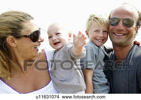 Picture - Happy family smiling at camera. Fotosearch