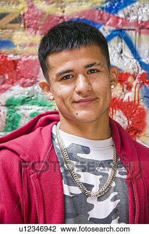 Stock Image - Hispanic Teenager against graffiti wall. Fotosearch
