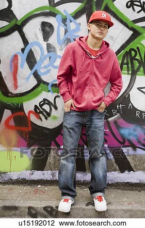 Stock Image - Hispanic Teenager against graffiti wall. Fotosearch