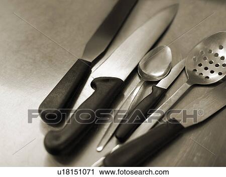 Stock Image - Kitchen implements on a steel table. Fotosearch