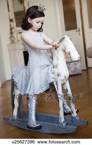 little girl riding a rocking horse View Large Photo Image Stock Photograph - little girl riding a rocking horse. Fotosearch