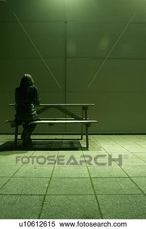 Stock Photography - lone woman sitting at bench. Fotosearch