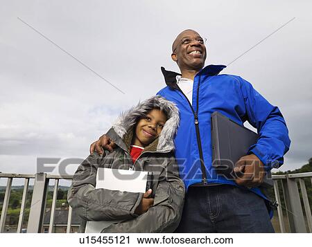 Stock Image - man and child holding laptops. Fotosearch