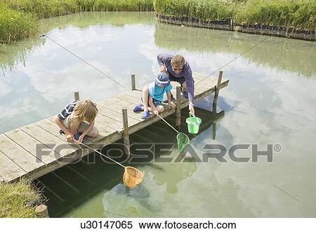 Stock Photography - Man and children fishing off jetty. Fotosearch