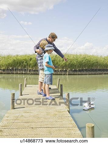 Man and children playing with toy boats View Large Photo Image Stock Image - Man and children playing with toy boats. Fotosearch
