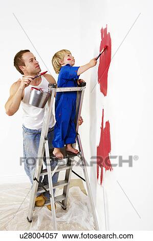 Stock Photo - Man and toddler boy painting wall red. Fotosearch