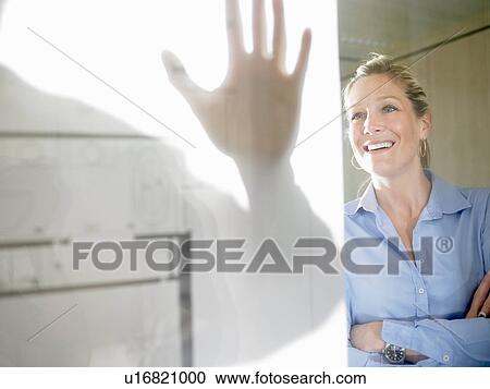 Stock Image - Man and woman behind blue prints. Fotosearch