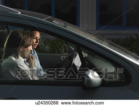 Stock Photo - man and woman meeting in car at night. Fotosearch