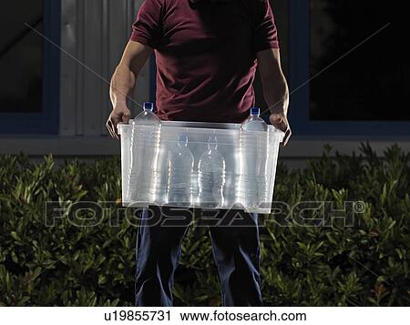 man carrying box of water at night View Large Photo Image Stock Image - man carrying box of water at night. Fotosearch