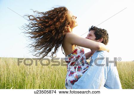 Picture - Man carrying woman in a wheat field. Fotosearch