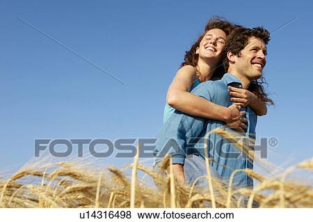 Man carrying woman in a wheat field View Large Photo Image Stock Photo - Man carrying woman in a wheat field. Fotosearch