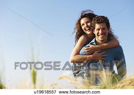 Stock Photo - Man carrying woman in a wheat field. Fotosearch