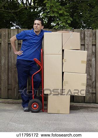 man delivering boxes on trolley View Large Photo Image Stock Image - man delivering boxes on trolley. Fotosearch