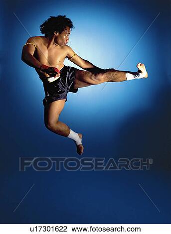 Stock Image - man doing jumping side kick. Fotosearch
