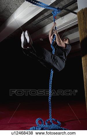 Stock Photo - man doing rope exercises. Fotosearch