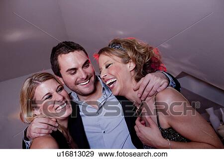Stock Photo - man embracing two women. Fotosearch