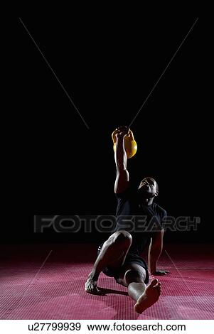 Stock Photo - man floor exercising with kettle bell . Fotosearch