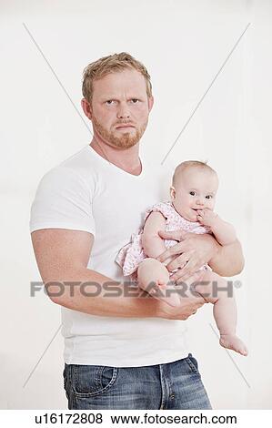 Man holding baby, looking grumpy View Large Photo Image Stock Photo - Man holding baby, looking grumpy. Fotosearch