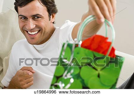 Man holding gift bag View Large Photo Image Stock Photograph - Man holding gift bag. Fotosearch