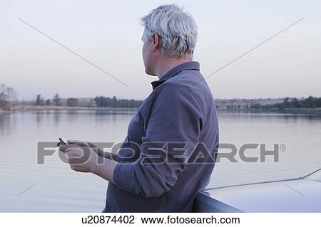 Man holding mobile phone View Large Photo Image Stock Image - Man holding mobile phone. Fotosearch