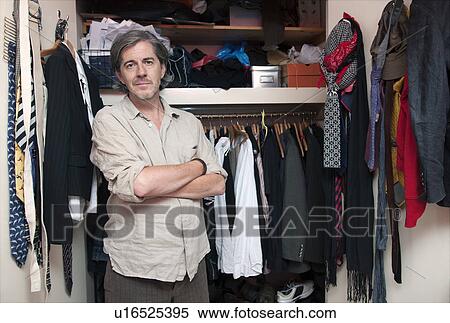 Stock Photography - man in front of wardrobe. Fotosearch