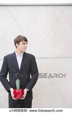 man in suit holding cactus View Large Photo Image Stock Image - man in suit holding cactus. Fotosearch