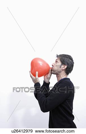 man inflating a heart balloon View Large Photo Image Stock Photo - man inflating a heart balloon. Fotosearch