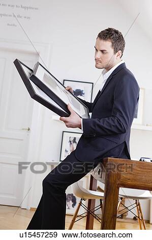 Stock Photo - man inspecting paintings. Fotosearch