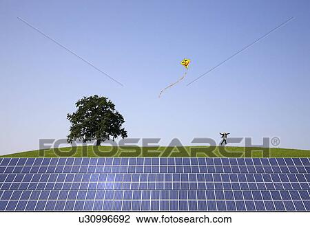 Stock Image - man jumping at solar power panels. Fotosearch